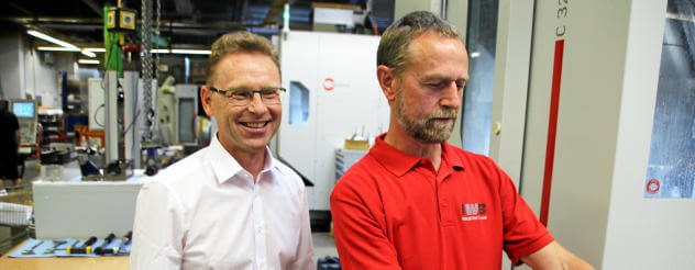 Geschäftsführer Ralf-Peter Kroschel (links) steht mit Mitarbeiter Ralf Fischer an einer CNC-Fräsmaschine. Der 60-Jährige arbeitet jetzt verkürzt, 32 statt 40 Stunden in einer Elternschicht. Foto: Wieland Fischer